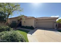 Charming home with a tile roof, lush landscaping, and a well-maintained front yard with artificial turf at 9475 N 115Th Pl, Scottsdale, AZ 85259