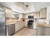 Updated kitchen with stainless steel appliances and granite countertops and tile backsplash at 9736 N 95Th St # 126, Scottsdale, AZ 85258