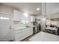 Well-designed kitchen featuring white cabinets, stainless steel appliances, and efficient layout at 11000 N 91St Ave # 70, Peoria, AZ 85345