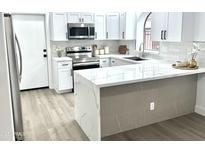 Bright kitchen featuring white cabinets, stainless steel appliances, and a quartz countertop island at 20917 N 37Th Pl, Phoenix, AZ 85050