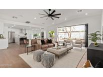 Bright living room features a modern ceiling fan, stylish furniture, and seamless indoor-outdoor flow to the backyard at 2632 E Mountain View Rd, Phoenix, AZ 85028