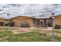 Charming single-story home features a well-maintained lawn, shrubs, and inviting facade in a quiet neighborhood at 17443 N 99Th N Dr, Sun City, AZ 85373