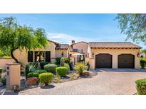 Charming home featuring a brick driveway, a well-manicured lawn and lovely desert landscaping at 18886 N 101St Way, Scottsdale, AZ 85255