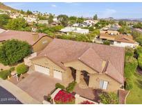 Aerial view of a home featuring a well maintained roof, landscaping, and attached two-car garage at 1954 E Vista Dr, Phoenix, AZ 85022