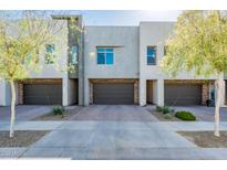 Contemporary townhome exterior featuring stone accents, private garages, and manicured landscaping at 25339 N 19Th Ln, Phoenix, AZ 85085