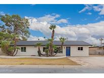 Charming single-story home with palm trees, blue door, and a well-maintained front yard at 3407 E Hubbell St, Phoenix, AZ 85008