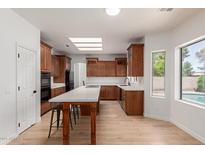 Well lit kitchen with oak cabinets, granite countertops, and a large island for dining at 5332 W Linda Ln, Chandler, AZ 85226