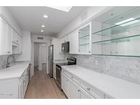 Bright white kitchen with marble countertops and backsplash, stainless appliances, and recessed lighting at 6349 N 78Th St # 123, Scottsdale, AZ 85250