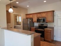 Well-lit kitchen featuring stainless steel appliances, ample wood cabinetry, and a pass-through breakfast bar at 9253 N Firebrick Dr # 143, Fountain Hills, AZ 85268