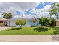 Charming, light blue single-Gathering home with a well-manicured lawn and solar panels on the roof at 12607 N 25Th Ave, Phoenix, AZ 85029