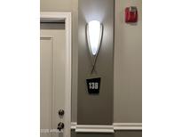 Hallway features a modern wall sconce and apartment number sign near a white door at 1701 E Colter St # 138, Phoenix, AZ 85016