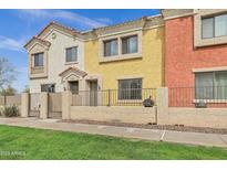 Charming townhome featuring a gated front yard and colorful stucco exterior at 1950 N Center St # 141, Mesa, AZ 85201
