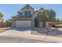 Two-story home with a neutral color scheme, a two-car garage, and a landscaped front yard with a small tree at 41581 W Somerset Dr, Maricopa, AZ 85138