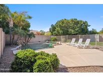 Backyard features a beautiful in-ground pool, lounge chairs and lush landscaping at 4829 E Charleston Ave, Scottsdale, AZ 85254