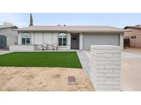 Charming single-story home features a manicured lawn, covered porch with chairs, and an attached two-car garage at 6225 W Mary Jane Ln, Glendale, AZ 85306