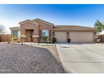 Charming single-story home featuring a three-car garage and low-maintenance desert landscaping at 1294 W Chimes Tower Dr, Casa Grande, AZ 85122