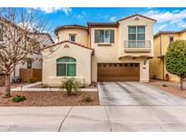 Charming two-story home features a brown two-car garage, stucco facade, and a delightful wrought-iron balcony at 1548 W Windhaven Ave, Gilbert, AZ 85233