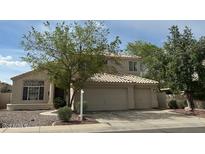 Inviting two-story home featuring a tile roof and a spacious three-car garage with landscaped front yard at 243 W Candlewood Ln, Gilbert, AZ 85233