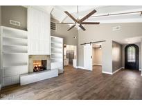 Spacious living room featuring a fireplace, built-in shelving, and wood-look tile flooring at 7309 E Rovey Ave, Scottsdale, AZ 85250