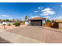 Charming single-story home featuring a brick driveway, dark garage door, and well-maintained front yard at 7715 N 23Rd Ave, Phoenix, AZ 85021