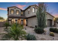 Elegant two-story home featuring a tiled roof and arched entryway, surrounded by desert landscaping at 3737 E Donald Dr, Phoenix, AZ 85050