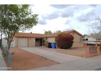 Tan single-story home featuring a brick front entryway, and a two-car garage at 3822 N 48Th Dr, Phoenix, AZ 85031