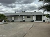 Charming single-story home featuring a flat roof, white exterior, and well-manicured landscaping at 4801 N 34Th Dr, Phoenix, AZ 85017