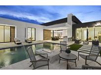 Backyard oasis featuring a sparkling pool with water features, fire pit, and luxurious outdoor seating at 7009 E Pasadena Ave, Paradise Valley, AZ 85253