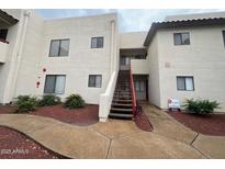 A bright three-story apartment building with a red staircase and landscaped entryway on a cloudy day at 750 E Northern Ave # 2085, Phoenix, AZ 85020