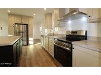 Well-lit kitchen featuring stainless steel appliances, granite countertops, and stylish cabinetry and flooring at 7836 E Javelina Ave, Mesa, AZ 85209