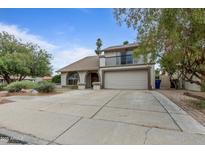 Charming two-story home featuring a balcony, arched entry, desert landscaping and a spacious driveway at 843 W Nido Ave, Mesa, AZ 85210