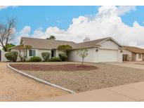 Charming single-story home with white exterior, well-maintained landscaping, and a two-car garage at 923 E Aire Libre Ave, Phoenix, AZ 85022