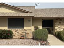 Traditional home exterior featuring a brick facade and well-maintained landscaping at 13423 W Countryside Dr, Sun City West, AZ 85375