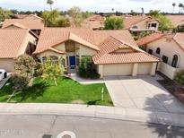 Charming single-story home featuring a well-manicured lawn and a beautiful blue front door at 1635 W Wisteria Dr, Chandler, AZ 85248