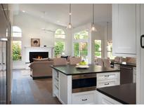 Open-concept living room featuring a fireplace, high ceilings, and seamless flow to the kitchen and outdoor spaces at 19219 N 88Th Way, Scottsdale, AZ 85255