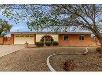 Charming brick home with a manicured front yard, mature tree, and inviting curb appeal at 3212 W Paradise Dr, Phoenix, AZ 85029