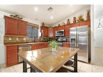 Well-lit kitchen features stainless appliances and granite countertops at 40142 W Coltin Way, Maricopa, AZ 85138