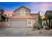 Charming two-story home features a red tile roof and desert landscaping, creating a welcoming curb appeal at 430 E Utopia Rd, Phoenix, AZ 85024