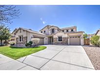 A luxurious two-story home with a three-car garage, stone accents, and a beautifully landscaped front yard at 6192 S Claiborne Ave, Gilbert, AZ 85298