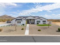 Striking single-story home with white exterior, desert landscaping and solar panels at 6645 N Paint Ln, Casa Grande, AZ 85194