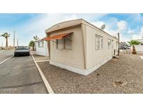 Cozy mobile home featuring gravel landscaping, awning, and neutral color scheme at 730 S Country Club Dr # 5, Mesa, AZ 85210