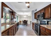 The kitchen includes stylish wood cabinets, granite countertops, and stainless steel appliances at 9809 W Pleasant Valley Rd, Sun City, AZ 85351