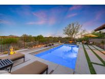 Stunning backyard pool view with beautiful landscaping, lounge chairs, and desert scenery at 10561 E Addy Way, Scottsdale, AZ 85262