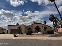 Charming single story home with desert landscaping, palm trees, and neutral color palette at 2077 N Lake Shore Dr, Casa Grande, AZ 85122