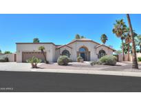 Charming home with desert landscaping, arched windows, and a neutral color palette at 2077 N Lake Shore Dr, Casa Grande, AZ 85122