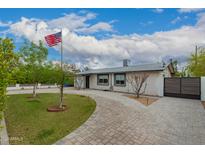 Charming single-story home featuring a well-manicured front yard with mature trees and a curved brick driveway at 4113 N 10Th Pl, Phoenix, AZ 85014