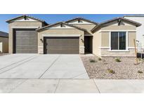Charming single-story home with a three-car garage, manicured gravel landscaping, and neutral color palette at 4946 W Weeping Willow Way, Laveen, AZ 85339