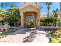 Inviting home entrance with lush landscaping, elegant archway, and double doors at 5335 E Shea Blvd # 2047, Scottsdale, AZ 85254