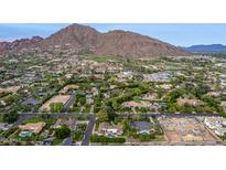 Expansive aerial view of a neighborhood with lush landscaping, pools, and a striking mountain backdrop at 5801 E Exeter Blvd, Phoenix, AZ 85018