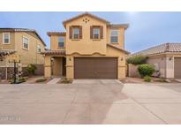 Charming two-story home featuring a brown two car garage and a well-maintained front yard at 6853 E Posada Cir, Mesa, AZ 85212
